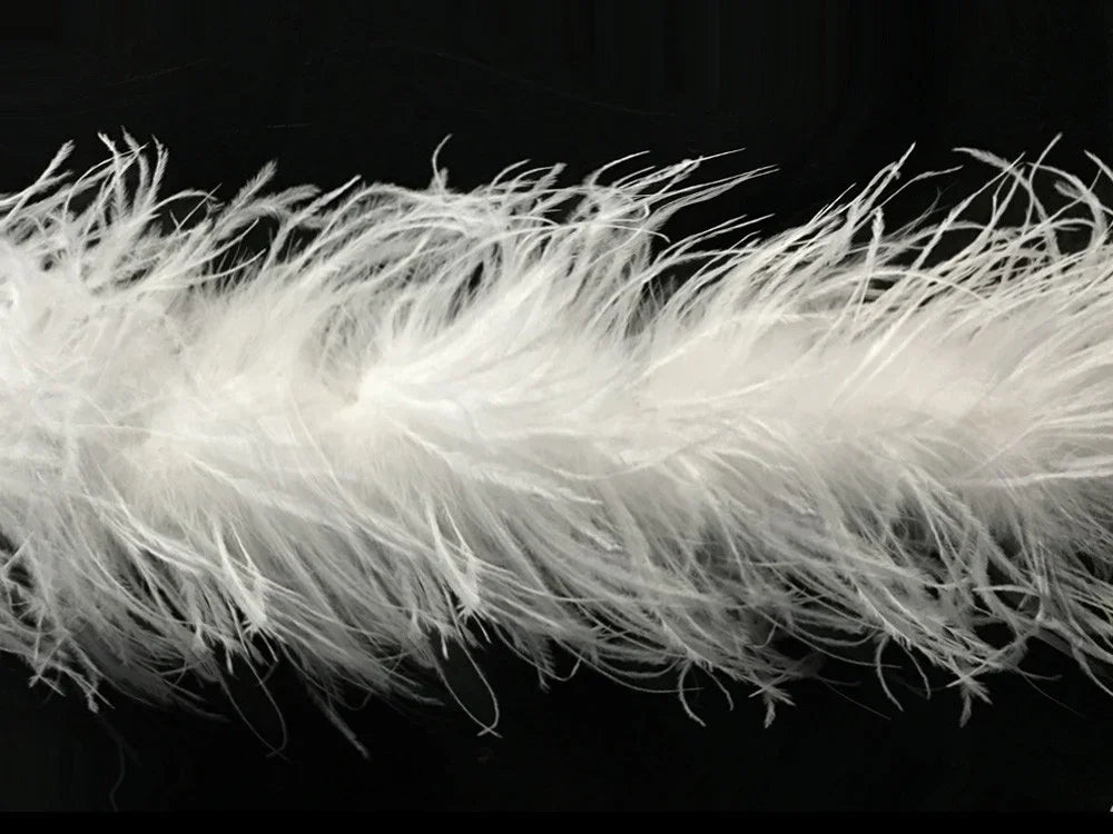 Soft white fluffy feather boa for fashion crafts and DIY décor against a black background.