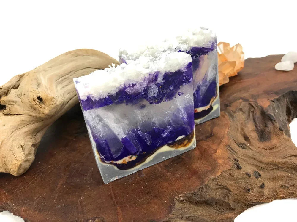 Handmade purple and white translucent soap bars with crystalline texture on wood decor