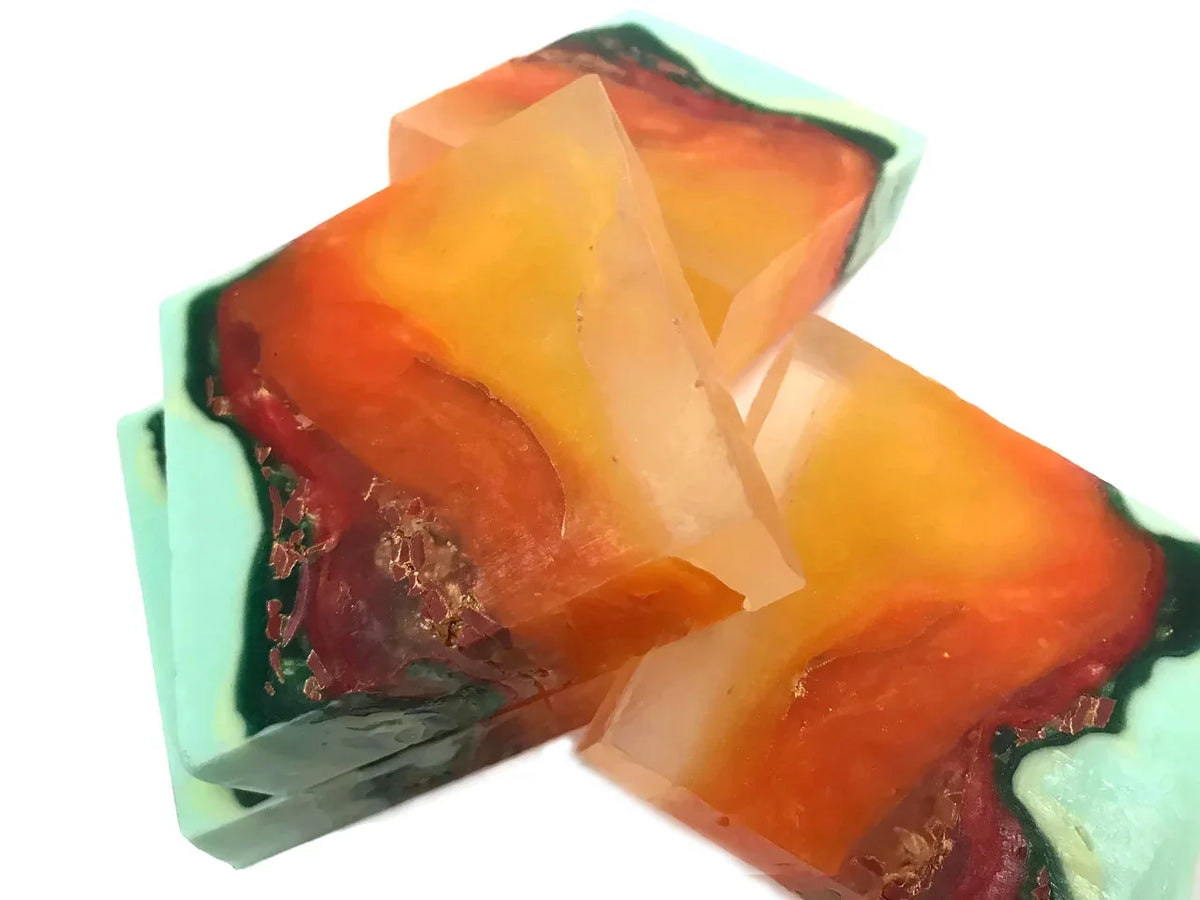 Artisanal handmade soap bars with vibrant orange, red, and teal swirl patterns.