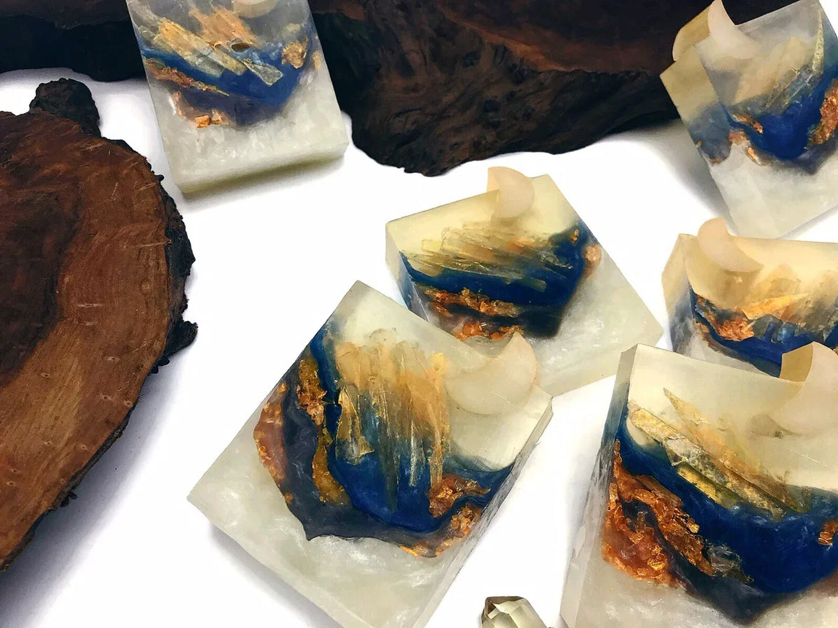 Resin art coasters with blue and gold foil accents and natural wood slices.