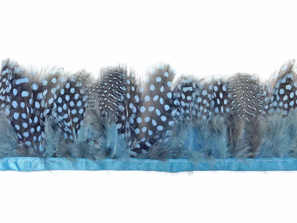 Blue and grey spotted feathers attached to a light blue ribbon trim for DIY crafts.