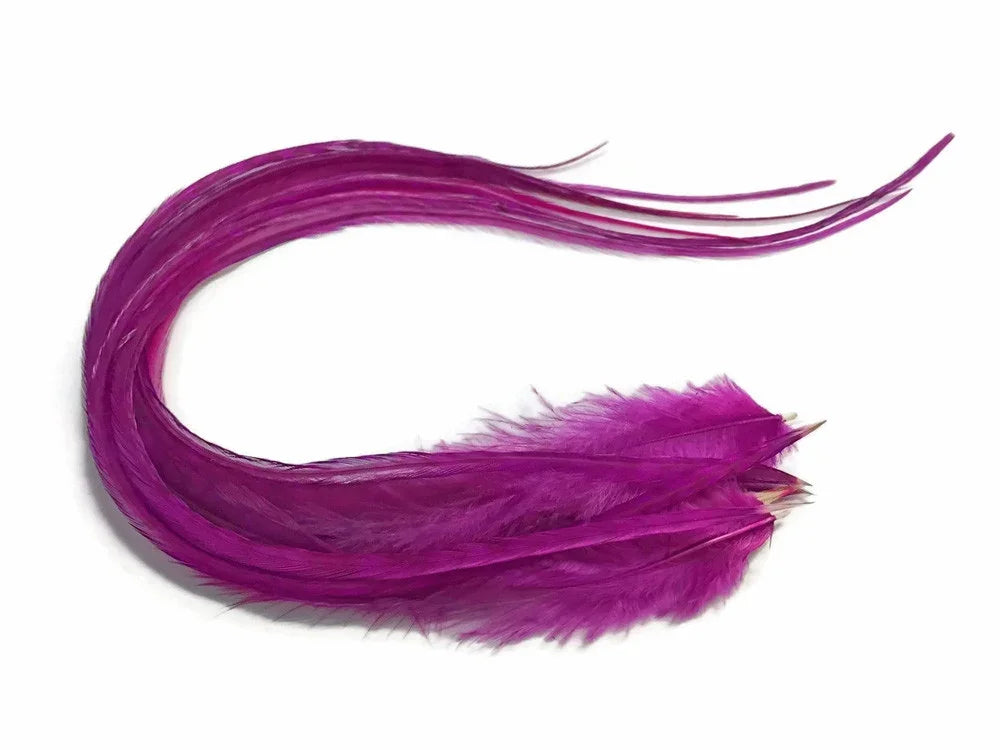 Vibrant magenta dyed feathers for craft and fashion DIY supplies on a white background.
