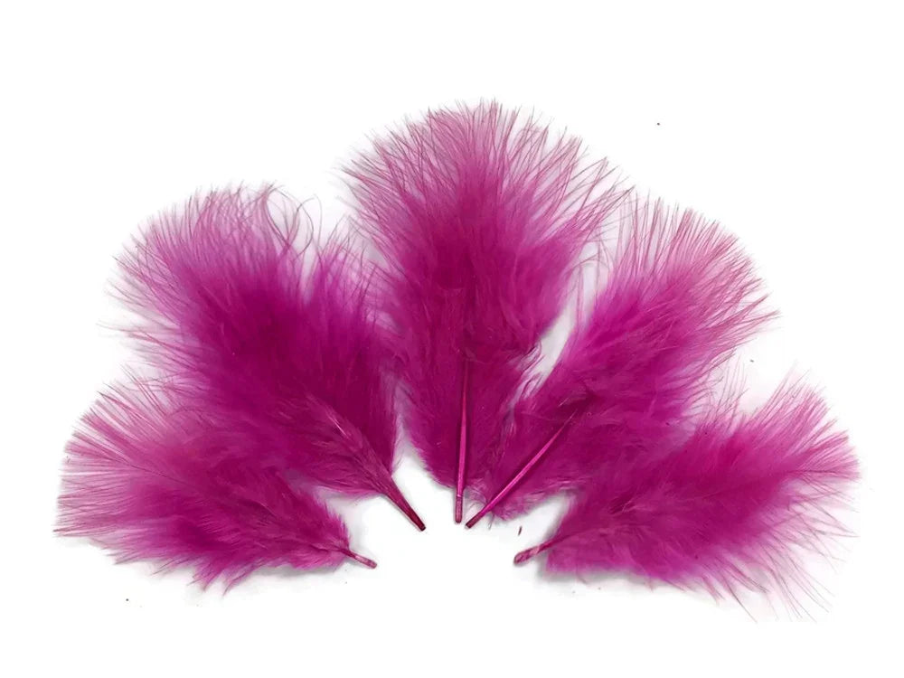 Vibrant magenta pink feathers for DIY crafts and fashion accessories on a white background.