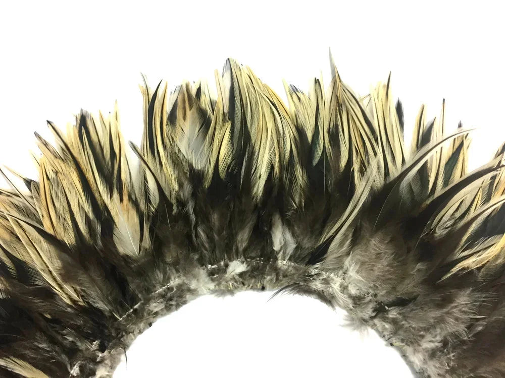 Natural gold and black patterned feathers arranged in a decorative arch for crafts.
