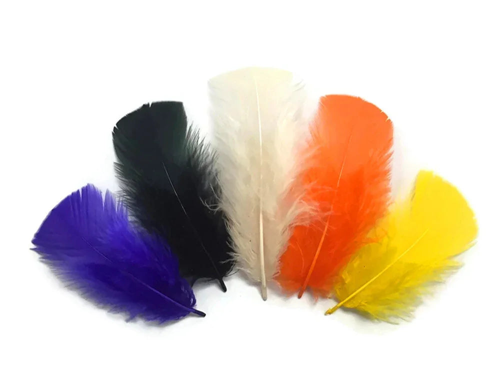 Vibrant assortment of colorful craft feathers in purple, black, white, orange, and yellow.