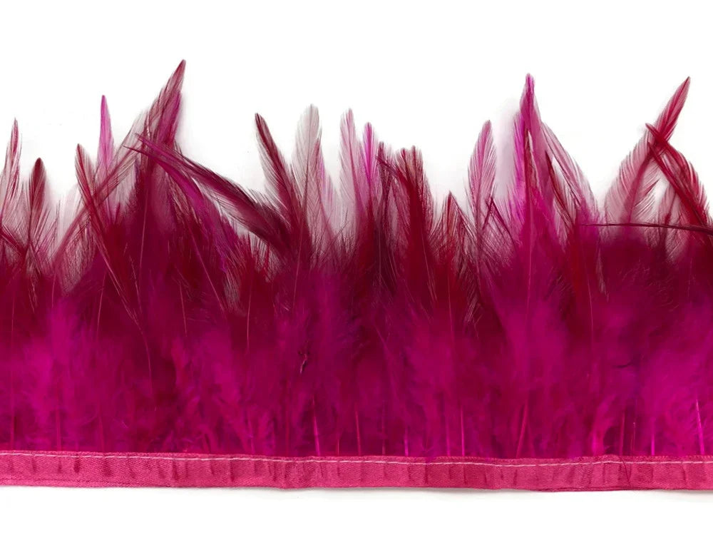Vibrant magenta pink feather trim strip for fashion and DIY crafts on white background.