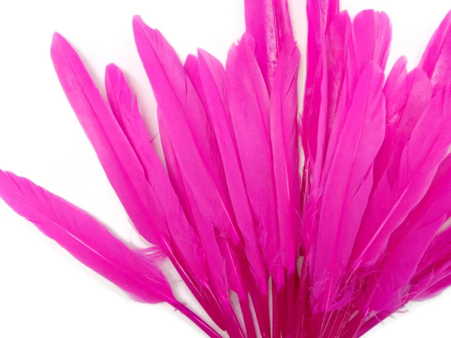 Vibrant hot pink feathers for DIY crafts and fashion accessories on a white background.