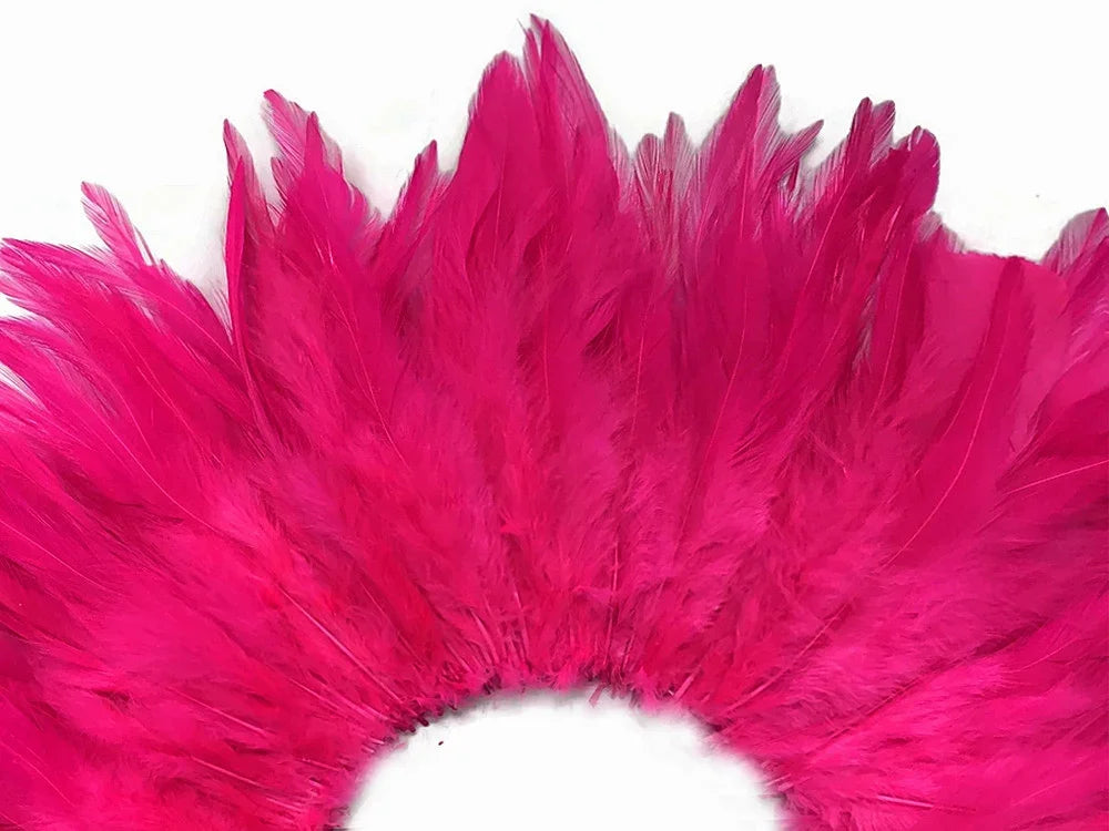 Vibrant hot pink feathers arranged in a decorative fan shape for crafts and fashion.