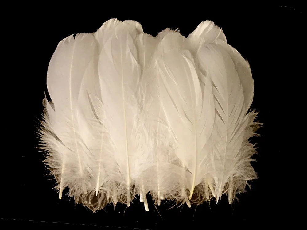 Soft white craft feathers for DIY fashion and decor against a black background