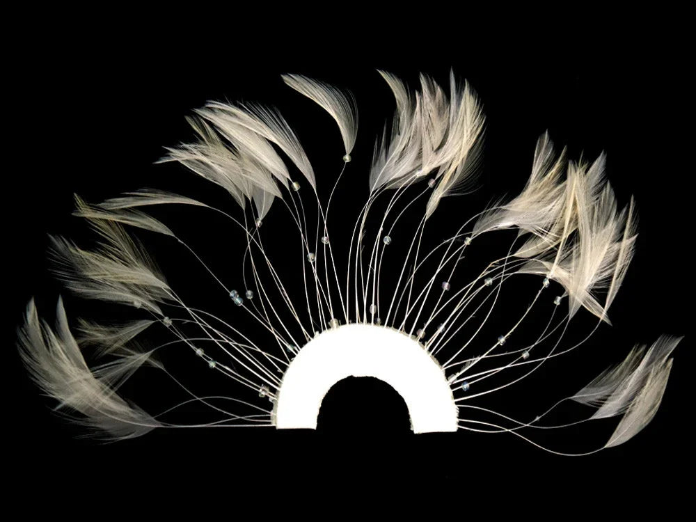Elegant cream-colored feathers with small beads arranged in a fan shape on a black background.