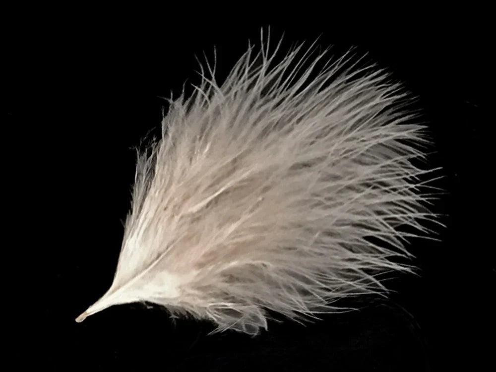 Soft white fluffy feather for DIY crafts and fashion accessories on a black background.
