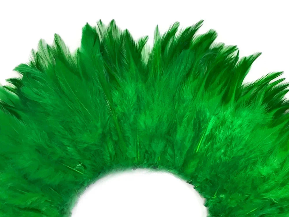Vibrant emerald green craft feathers arranged in a decorative semi-circle on a white background.