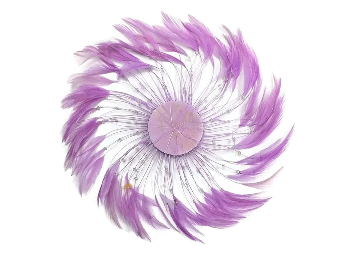 Purple feather hair accessory with sparkling crystal accents in a circular design.