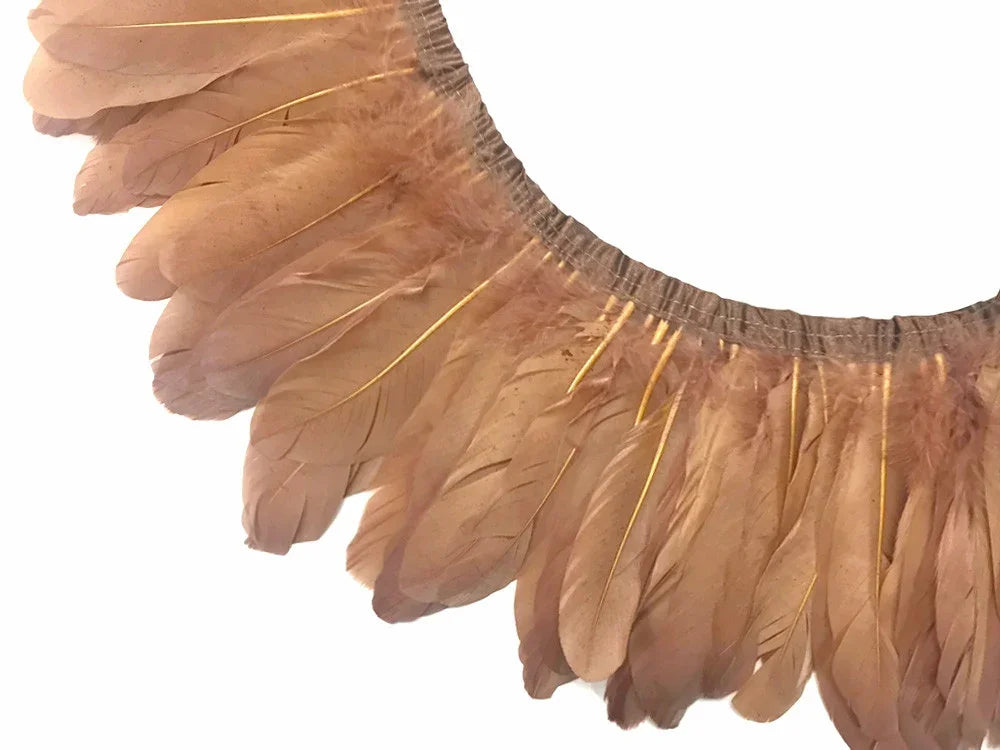 Natural beige feathers attached to a decorative trim for DIY crafts and fashion accessories.