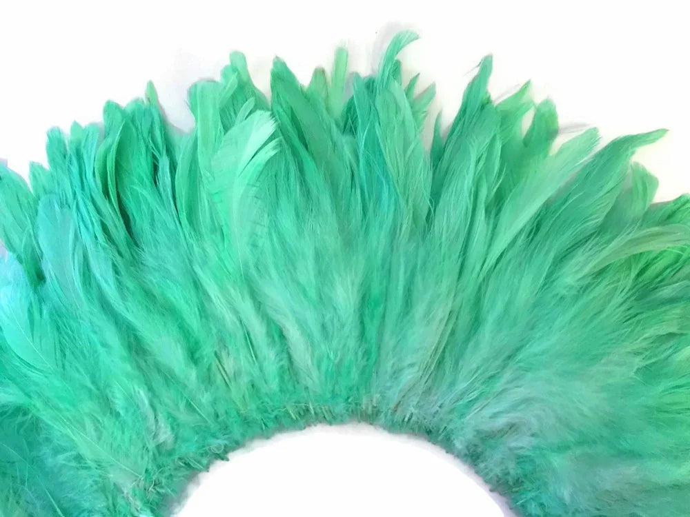 Vibrant teal green feathers arranged in a decorative fan shape for crafts and fashion.