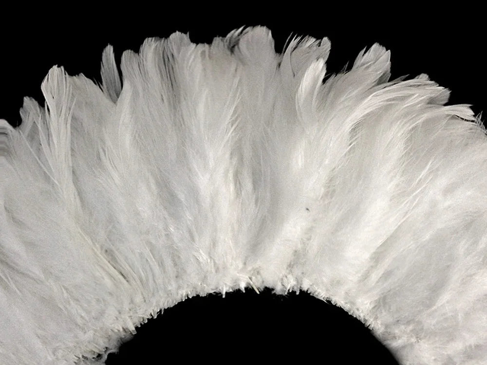 Soft white fluffy feathers arranged in a semi-circle against a black background.