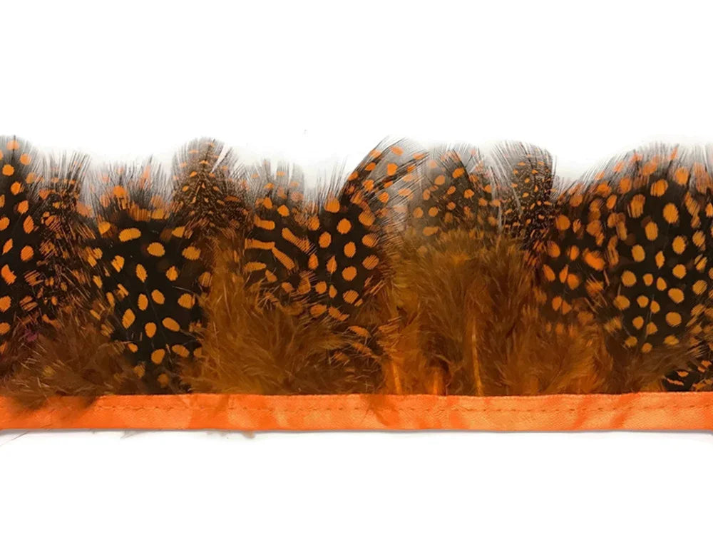 Orange and black spotted guinea fowl feathers trim on an orange ribbon base.