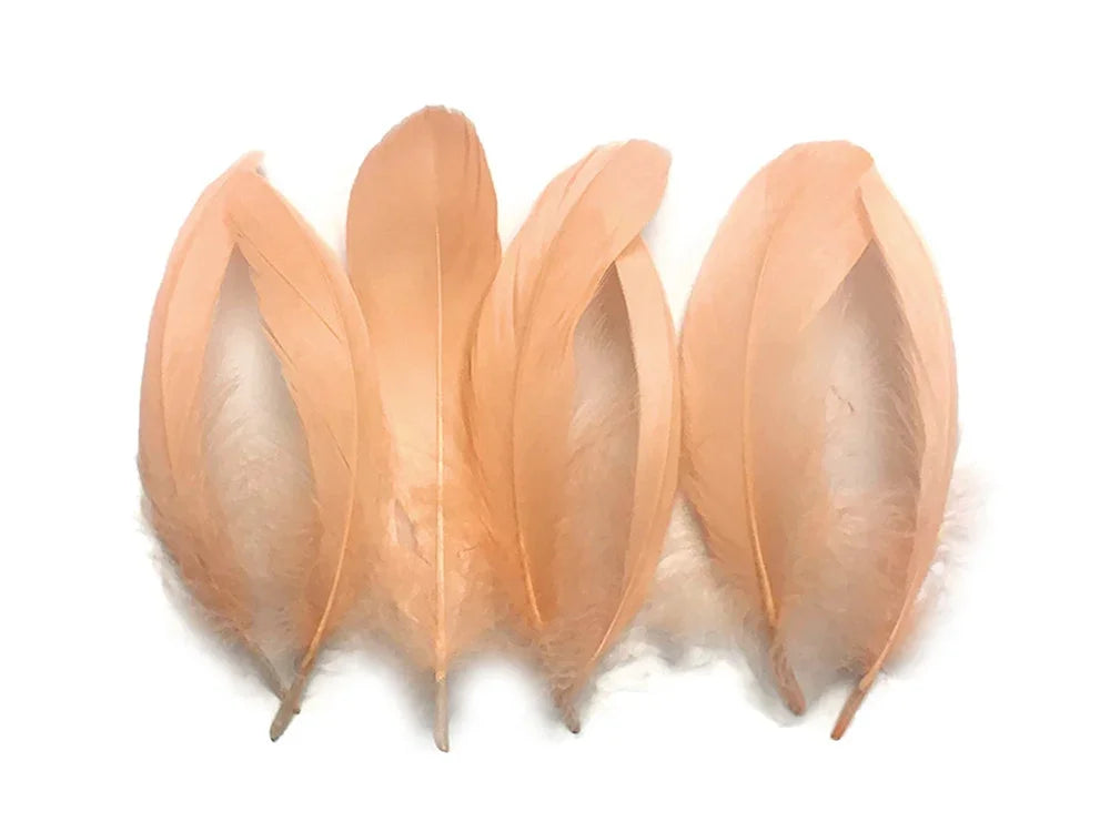 Four peach-colored natural feathers for crafts and DIY fashion decor.