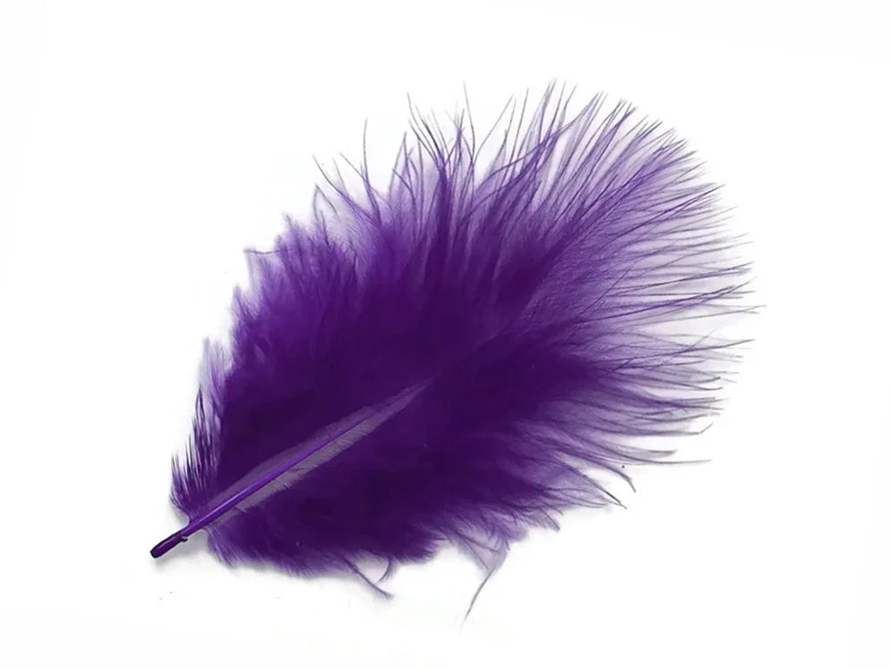 Vibrant purple craft feather for DIY fashion and décor accessories isolated on white.