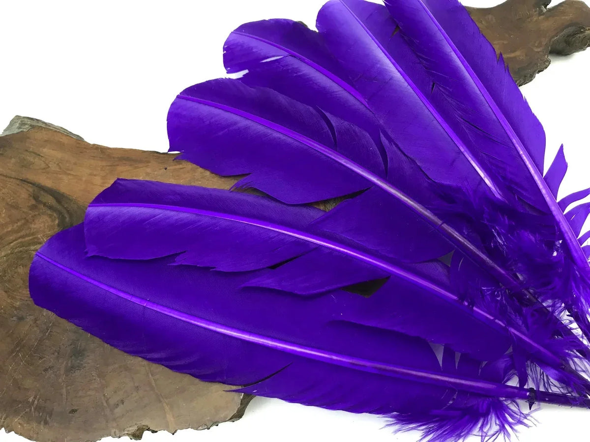 Vibrant purple feathers for crafts and fashion decor on a rustic wood slice.