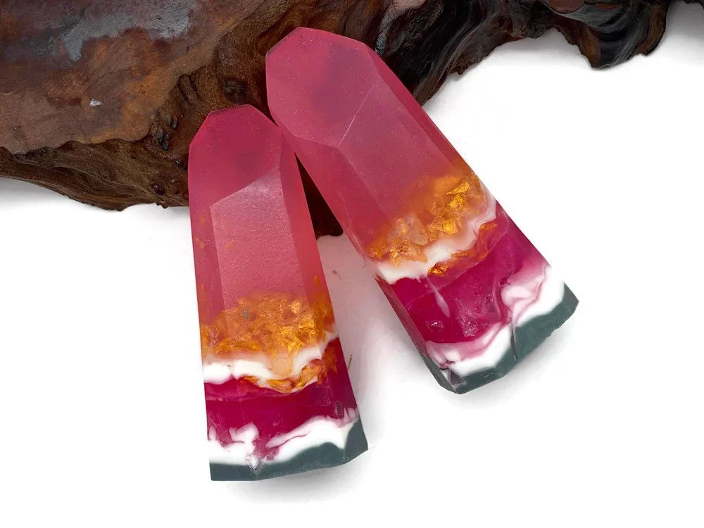 Two pink resin crystal towers with gold leaf flakes and white marble accents.
