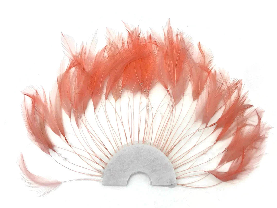 Peach colored decorative feathers arranged in a fan shape for DIY crafts and fashion.