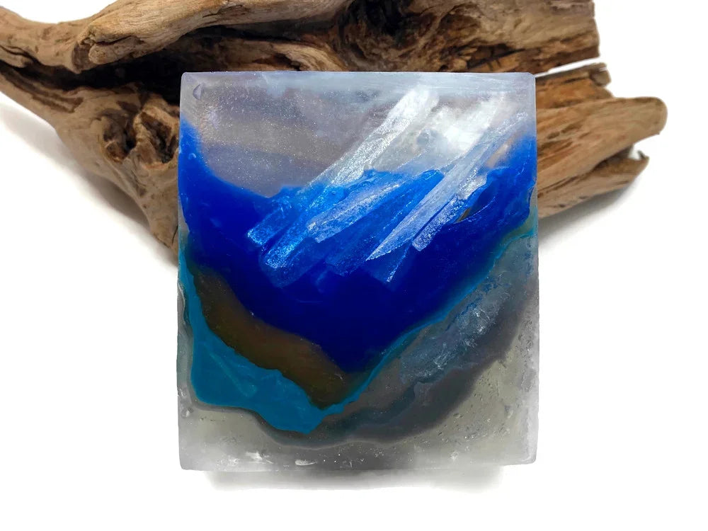 Square resin art piece with blue ocean wave patterns and natural wood background.