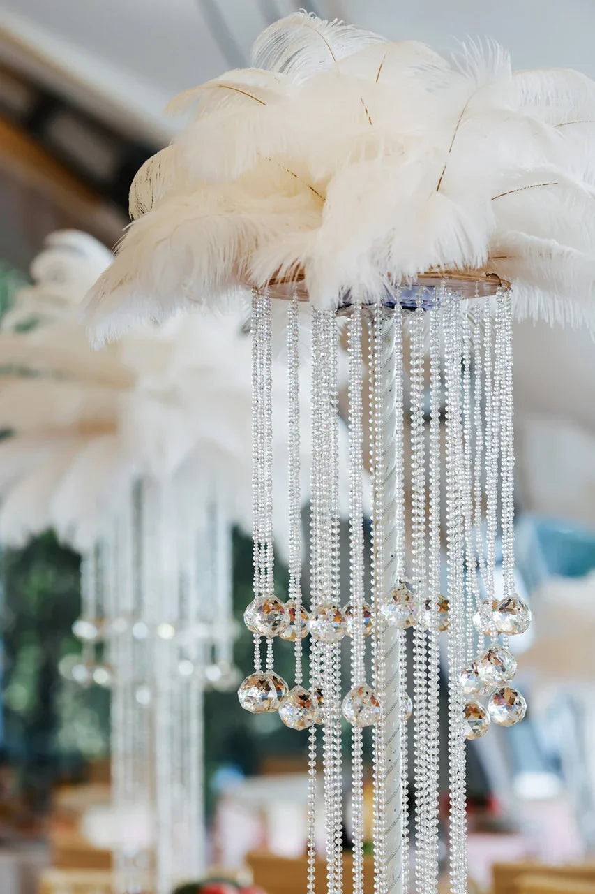 Elegant white ostrich feather centerpiece with hanging crystal bead strands.