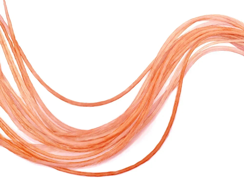 Long peach-colored decorative feathers for DIY crafts and fashion accessories.