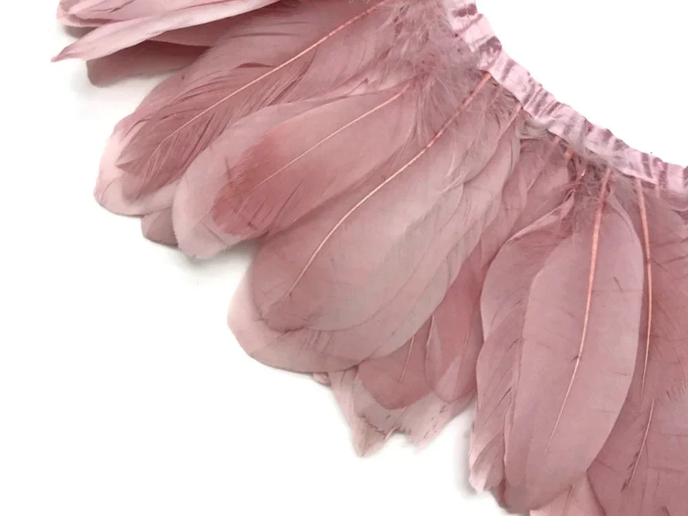 Soft pink feathers attached to a decorative trim for crafts and fashion DIY projects.