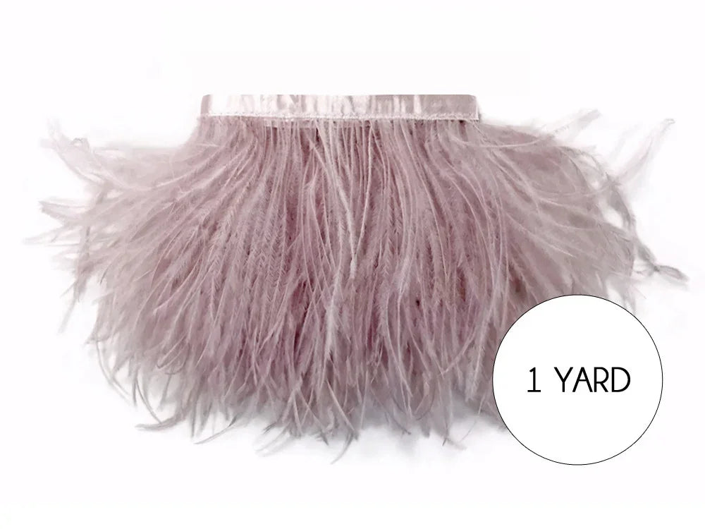 One yard of soft dusty pink ostrich feather trim for DIY fashion and crafts.