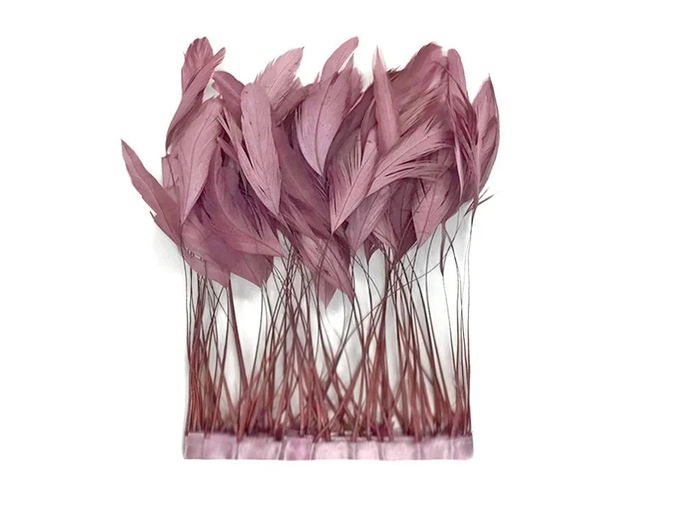 Dusty rose pink feathers for DIY crafts and fashion accessories on a white background.