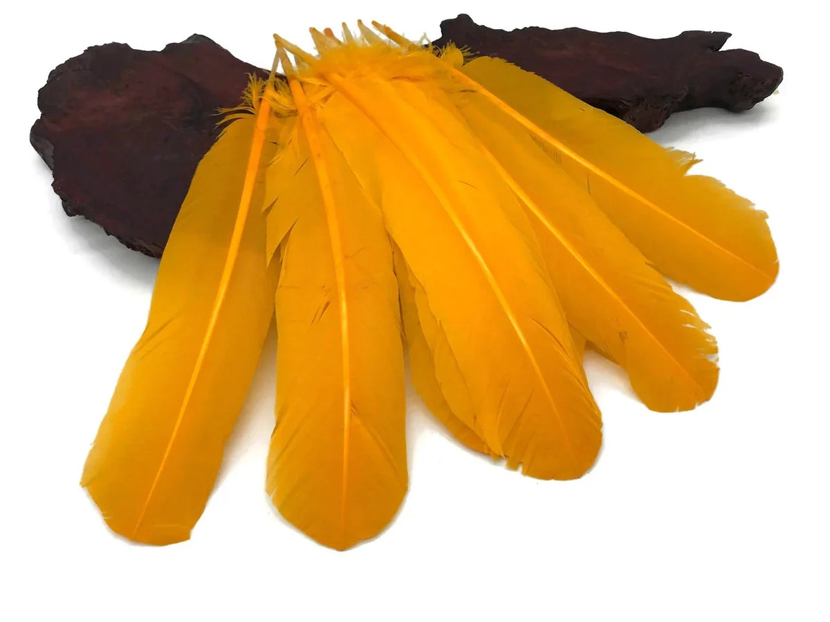 Vibrant yellow craft feathers arranged on a dark decorative stone base.