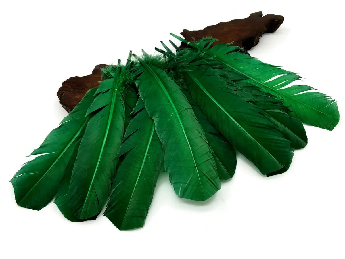 Vibrant green craft feathers arranged on a dark wood piece against a white background.