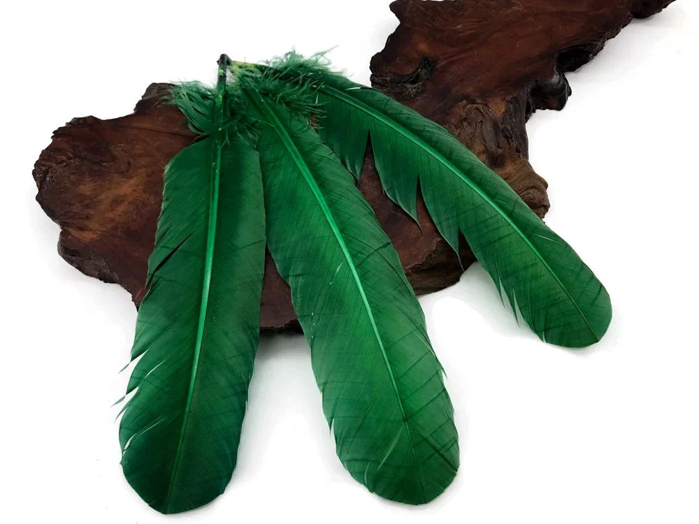 Three vibrant emerald green feathers resting on a natural dark wood decorative base.