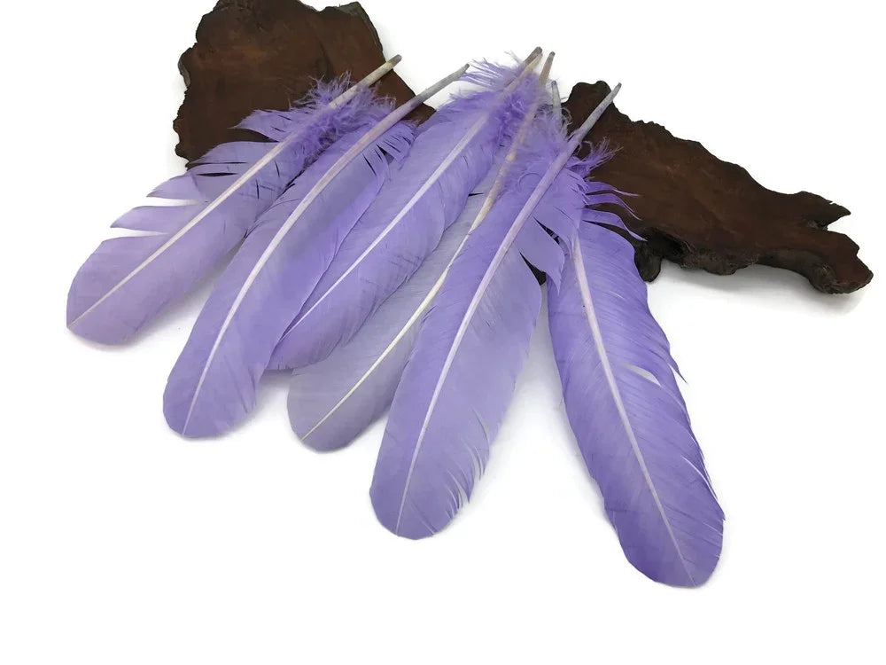 Soft lavender purple craft feathers arranged on a natural wood piece.