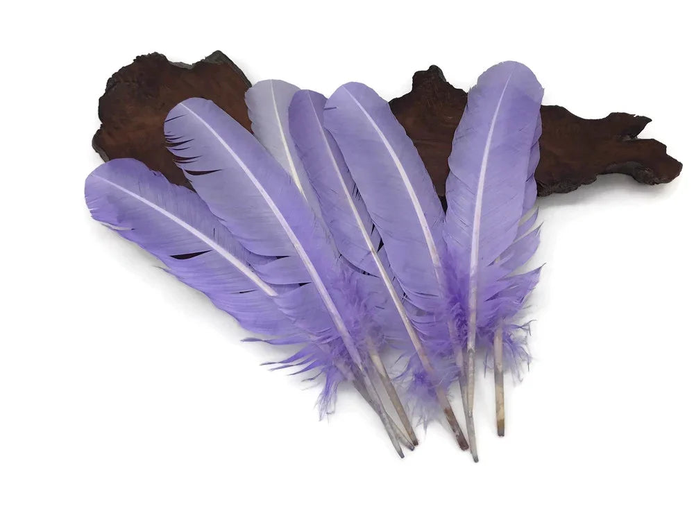 Bundle of vibrant purple craft feathers on a dark wood base.