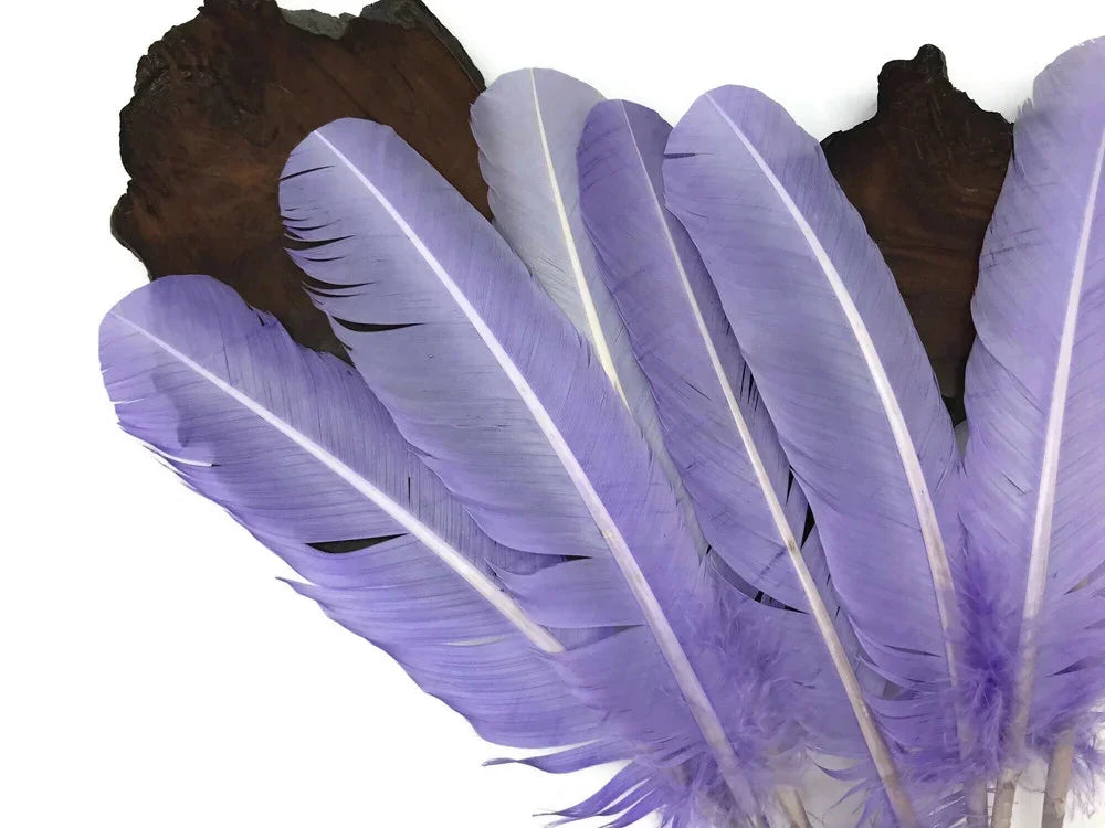 Vibrant lavender purple feathers for DIY crafts and fashion decor on a dark wood background.