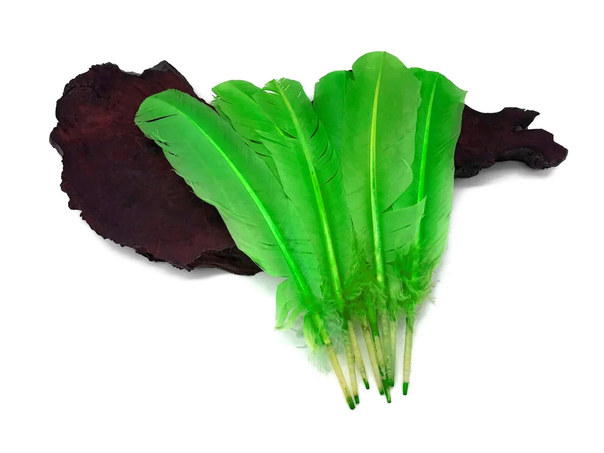 Vibrant bright green craft feathers displayed on a dark wood slice background.