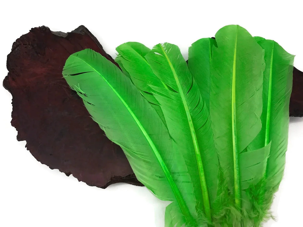 Vibrant green craft feathers displayed on a dark natural wood slice.