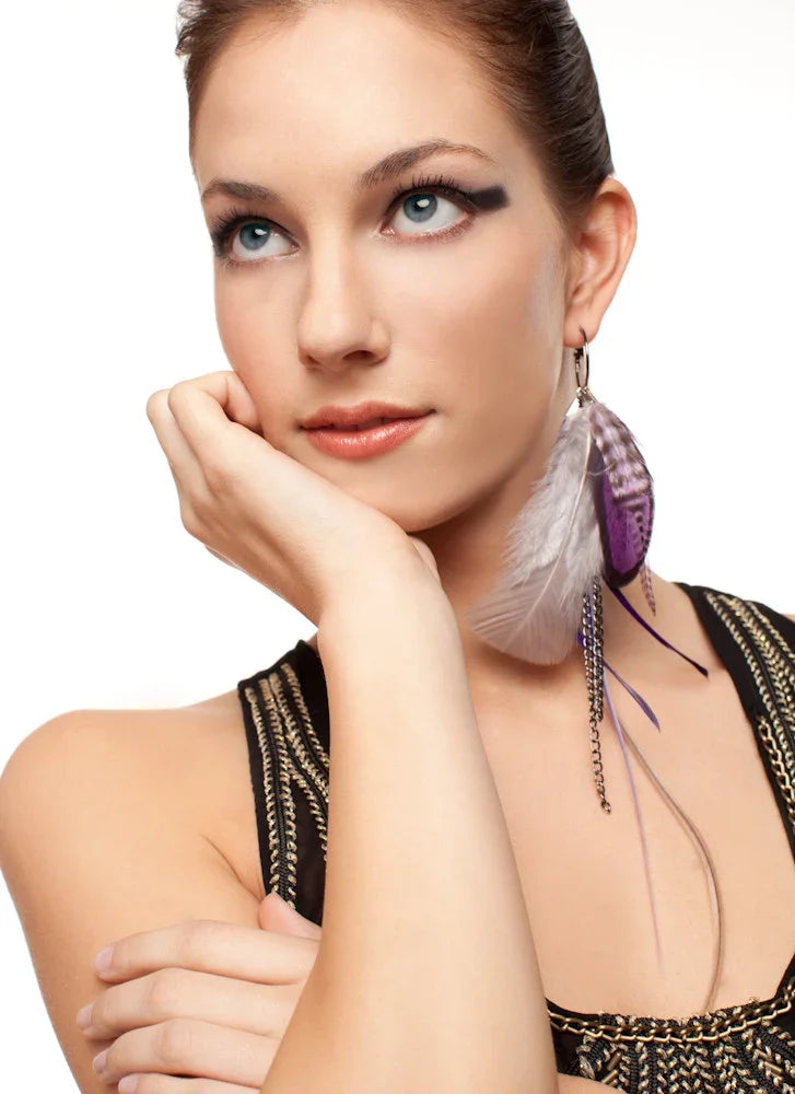 Woman wearing elegant purple and white feather earrings for fashion accessories.
