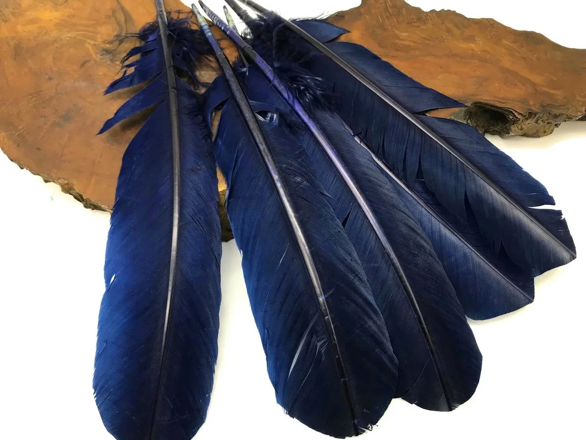 Deep blue dyed feathers for DIY crafts and fashion accessories on a wooden base.