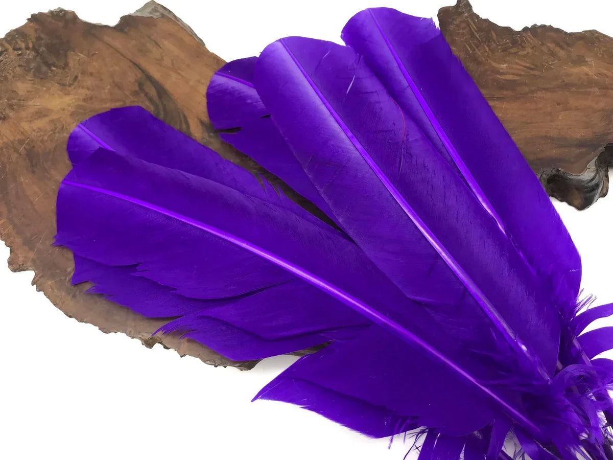 Vibrant purple craft feathers displayed on a rustic wood slice background.